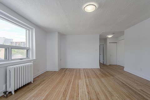 the living room and dining room with wood flooring and a large window